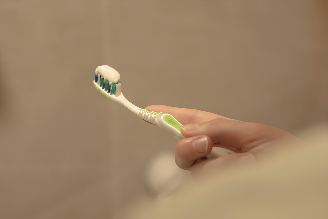 Oral care products including a glass of water and mouth rinse on a bathroom counter