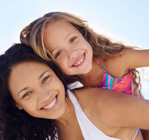 young woman and little girl smiling