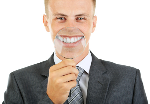 Man with magnifying glass over his mouth